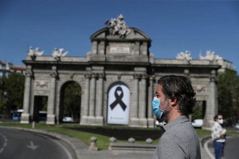 متظاهرون يحملون أعلام إسبانيا ضد تعامل الحكومة مع جائحة كورونا -رويترز