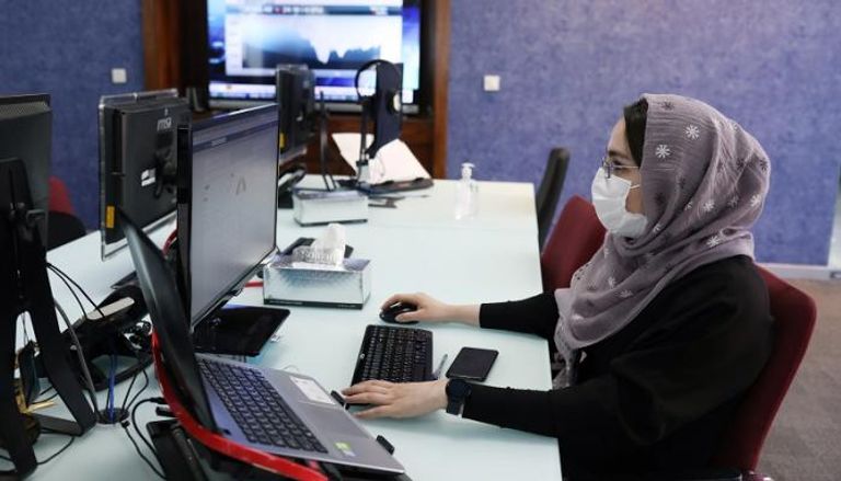 إيرانية ترتدي الكمامة للوقاية من فيروس كورونا خلال أداء عملها