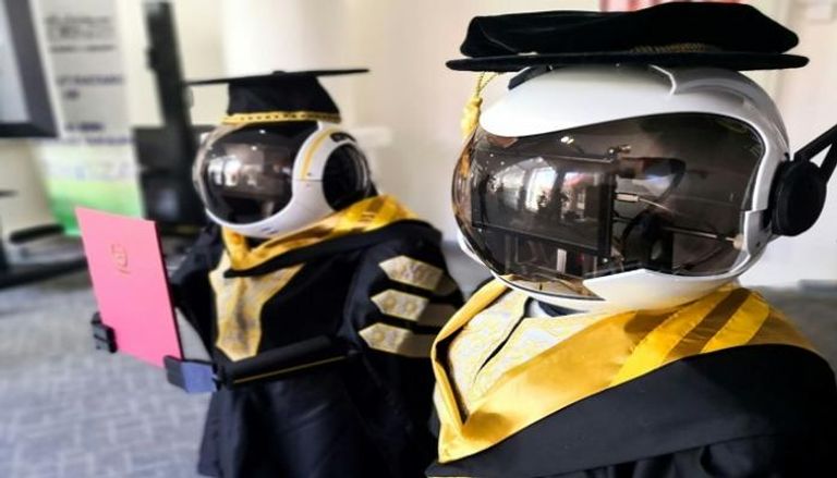 صورة تظهر روبوتين يلبسان ثوب التخرج خلال محاكاة لمراسم تخرج الطلاب