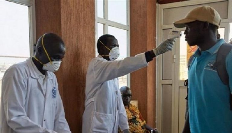 طبيب يفحص درجة حرارة مواطن سوداني