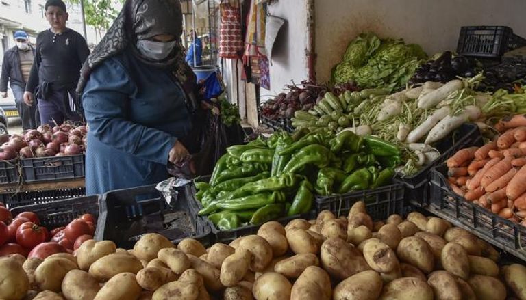 جزائرية ترتدي الكمامة في سوق الخضار للوقاية من فيروس كورونا