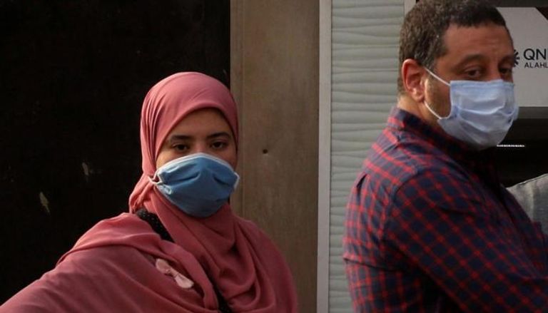 مصريان يرتديان الكمامة للوقاية من فيروس كورونا
