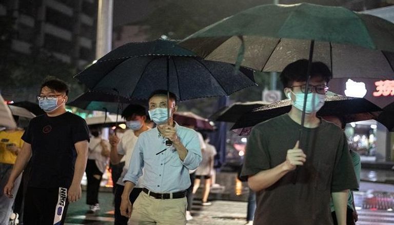 أشخاص يرتدون قناع الوجه الواقي في شنتشن جنوب الصين  