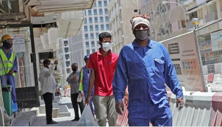عمال في قطر يرتدون الأقنعة 