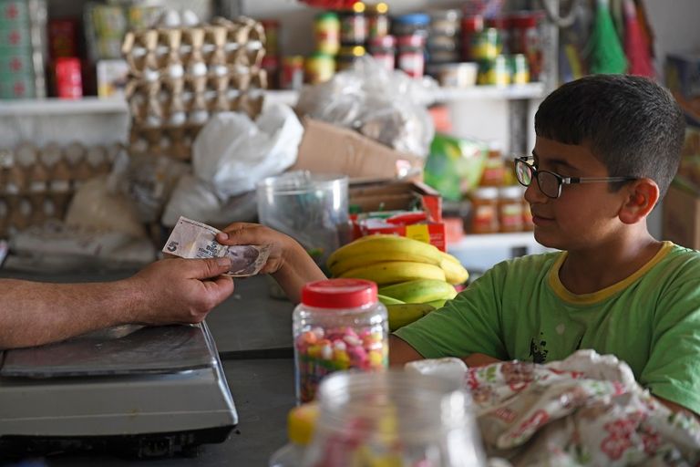 سوريون يشترون الخبز في بلدة بنش بمحافظة إدلب - أ ف ب