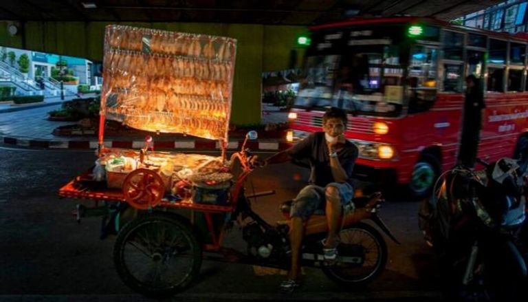 بائع مأكولات بحرية متجول في تايلاند ينتظر الزبائن