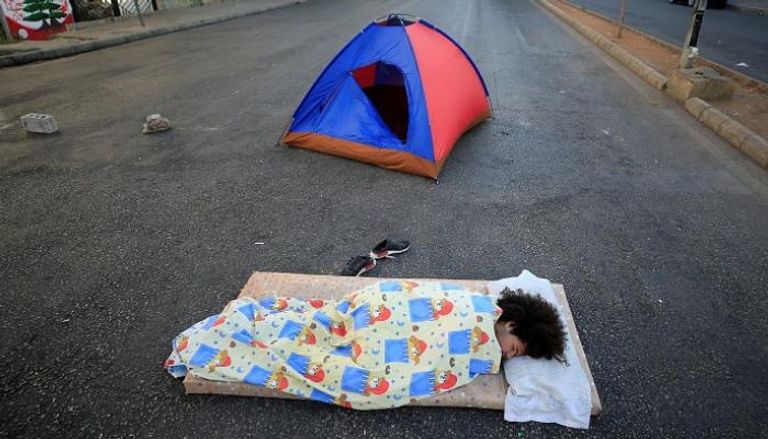لبناني ينام وسط الطريق بعد احتجاجات ليلية على انخفاض الليرة