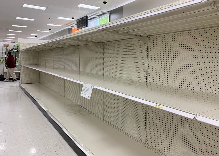 رجل يحمل أوراق تواليت بينما يهبط درج سلم كهربائي