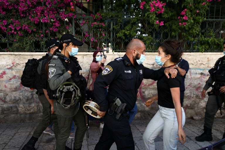 برازيلي يرتدي الكمامة ويسير بجوار حائط عليه جرافيتي عن مكافحة الفيروس