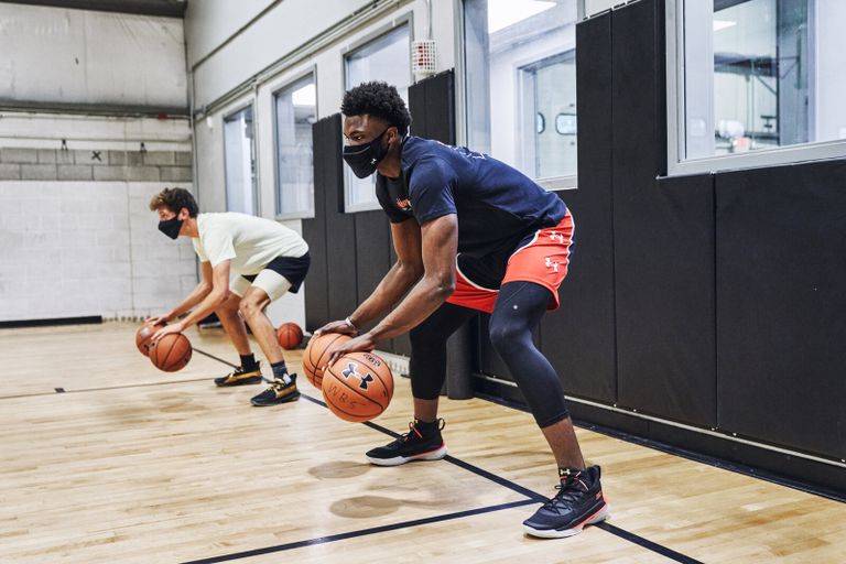 لاعبو كرة السلة يتدربون وهم يرتدون كمامة شركة "أندر آرمور" الأمريكية "UA Sport mask"، أو الكمامة الرياضية.