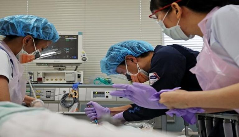 أطباء صينيون يعالجون مصابا بكورونا في أحد المستشفيات 