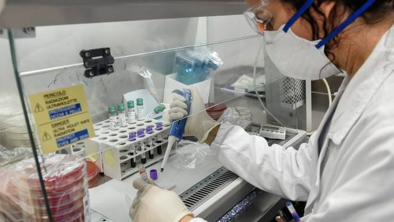 طبيب إيطالي يحمل عينات قبل إجراء فحوص كورونا عليها