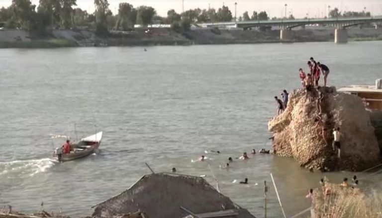 عدد من سكان بغداد يسبحون في نهر دجلة