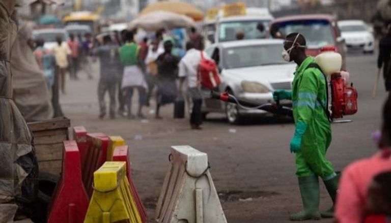 عامل يعقم أحد الشوارع في غانا - سي إن إن