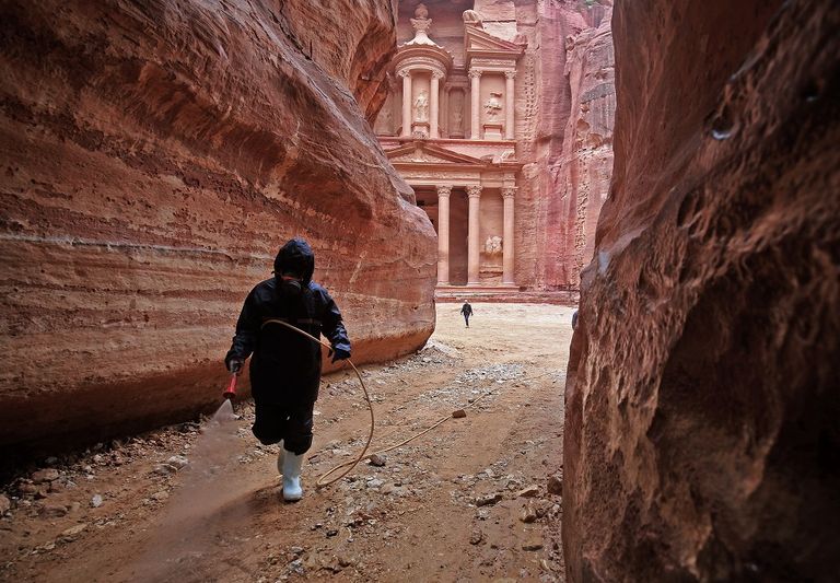 عامل يرش المطهرات في مدينة البتراء الأردنية