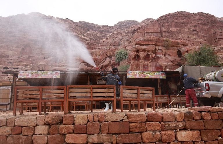 عامل يرش المطهرات في مدينة البتراء الأردنية