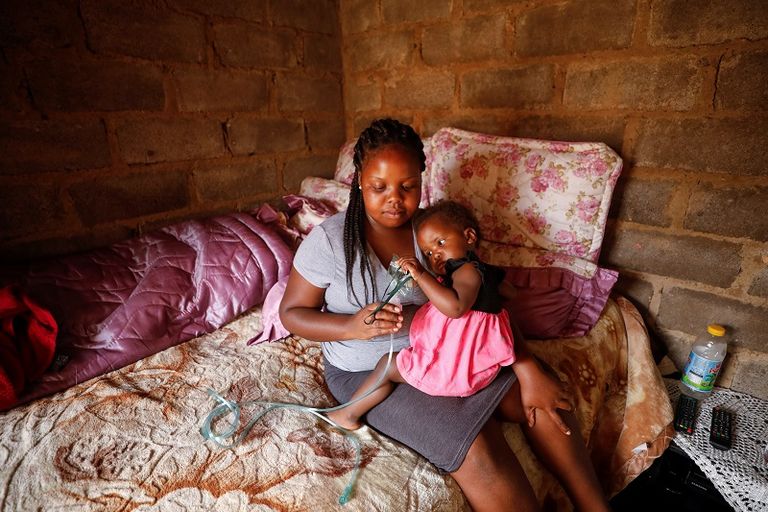 هندي يفتح فمه لأخذ مسحة من لعابه بينما يبدو كمن يصرخ مستغيثا من كورونا