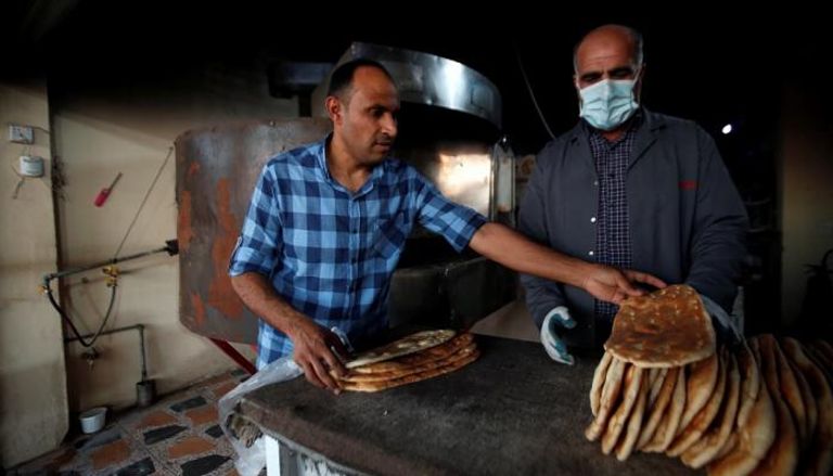 رجل يرتدي كمامة في مخبز بمدينة أربيل
