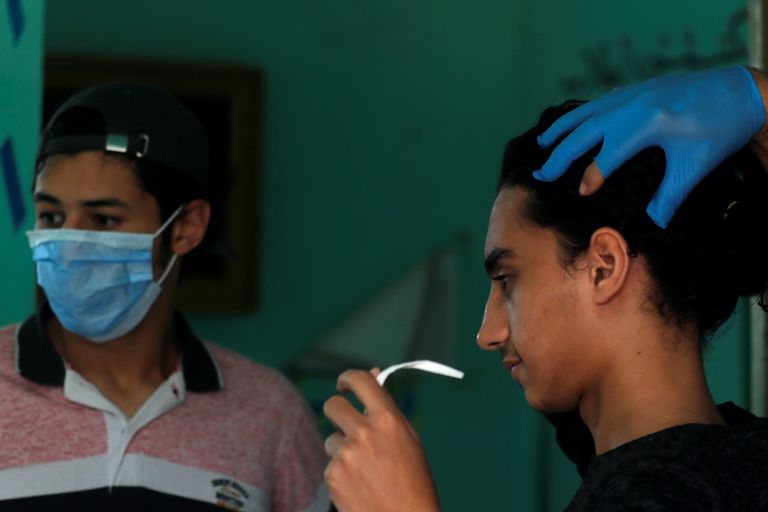 طالب يرتدي الكمامة قبل دخوله امتحان اللغة العربية للثانوية العامة في مصر صورة لإحدى لجان امتحانات الثانوية العامة في مصر