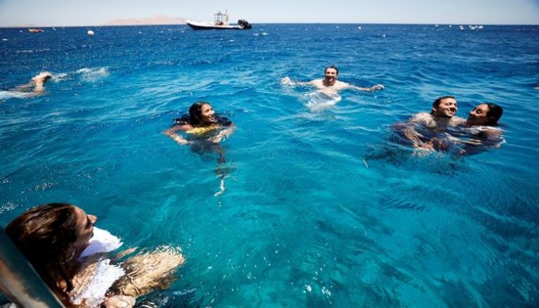سائحون يسبحون في خليج العقبة بمنتجع شرم الشيخ المطل على البحر الأحمر - رويترز