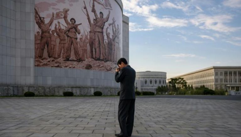 رجل يقف أمام متحف الحرب في كوريا الشمالية