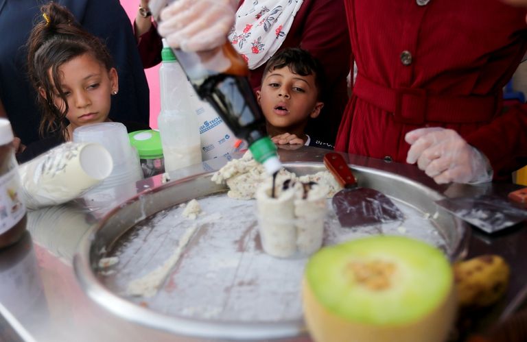 فاطمة تصنع لفائف البوظة على عربة أمام متجرها الصغير