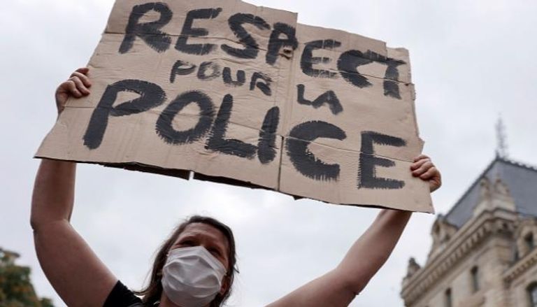 متظاهرة فرنسية ترفع لافتة "احترموا الشرطة" - رويترز