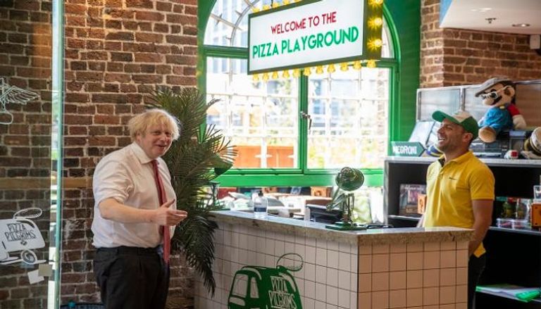 رئيس الوزراء البريطاني في مطعم بيتزا يستعد لإعادة الافتتاح في 4 يوليو - أ ف ب