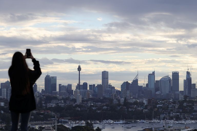 فتاتان تجلسان على مقعد يطل على دار أوبرا سيدني