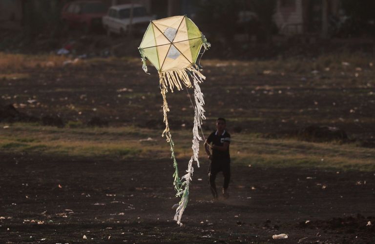 طفل مصري يحاول تحليق طائرة ورقية في إحدى قرى مصر