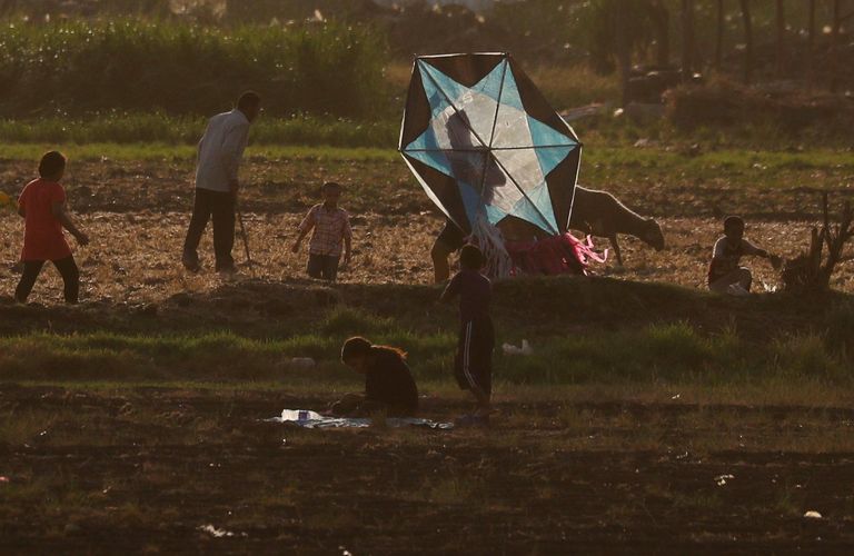 مجموعة أطفال تحاول تحليق طائرة ورقية في إحدى قرى مصر