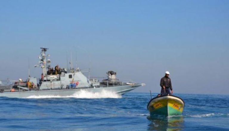 قارب صيد فلسطيني وقطعة بحرية إسرائيلية قبالة غزة - أرشيفية