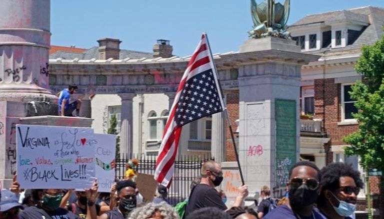 متظاهر يرفع العلم الأمريكي مقلوبا دعما لمناهضة العنصرية