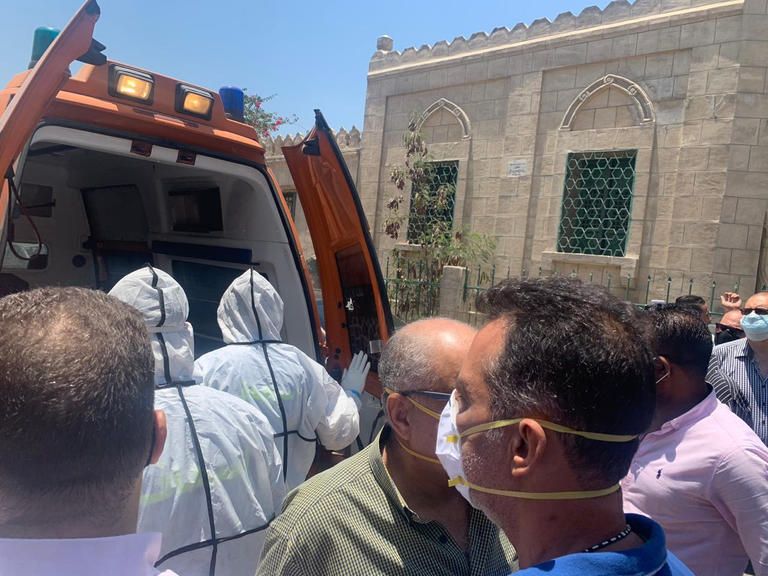 سيارة إسعاف تصل المقابر، وتحمل جثمال الفنانة المصرية الراحلة رجاء الجداوي، وطاقم طبي يرتدي بدل واقية