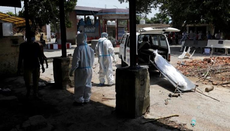 عاملون صحيون ينقلون جثمان امرأة توفيت بفيروس كورونا في الهند