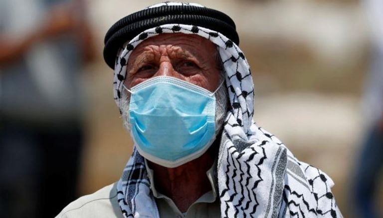 فلسطيني يرتدي كمامة للوقاية من فيروس كورونا