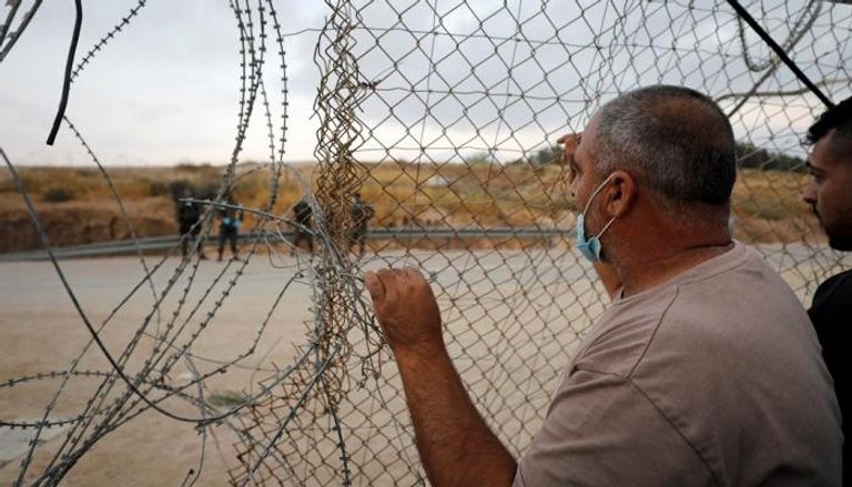 فلسطيني يقف أمام أحد المعابر الإسرائيلية