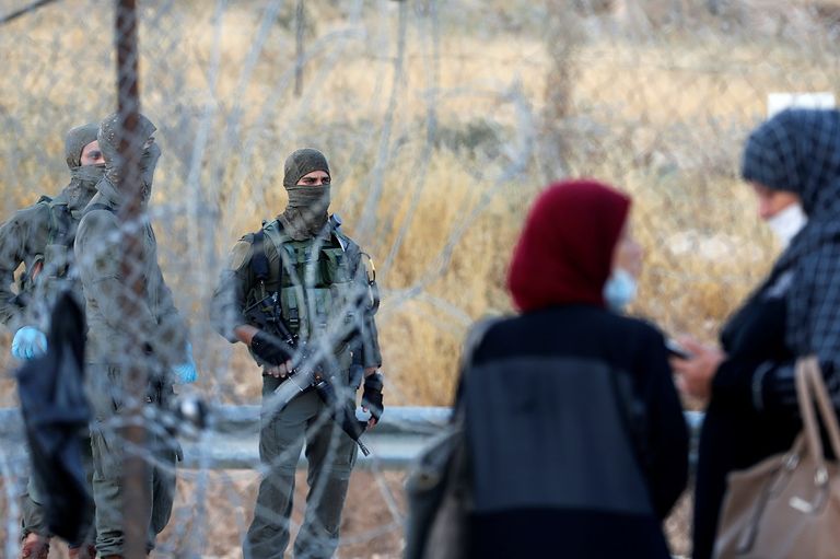 فلسطيني يقف أمام أحد المعابر الإسرائيلية