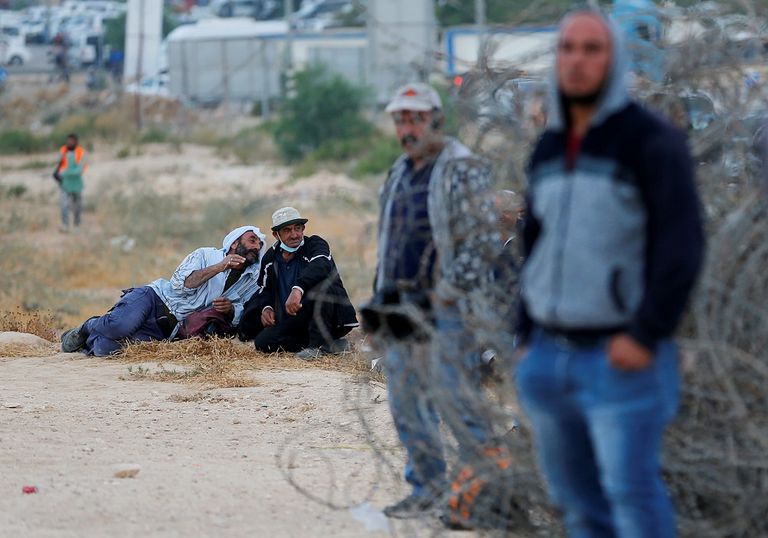 فلسطيني يقف أمام أحد المعابر الإسرائيلية