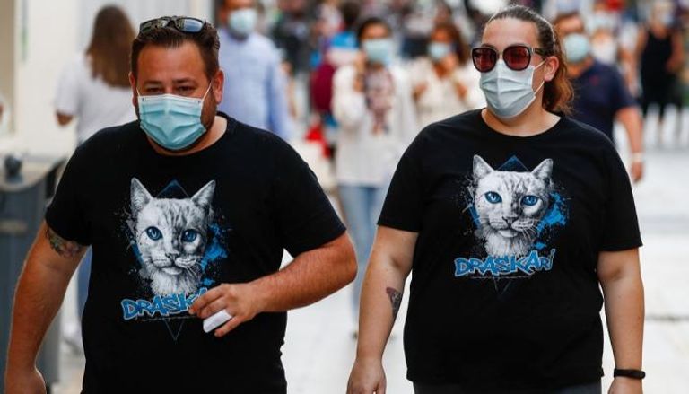 شخصان يرتديان كمامتين للوقاية من فيروس كورونا