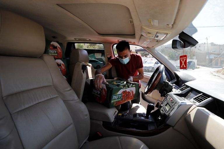 المزارع الفلسطيني محمود أبو مقدام يحمل أحد صناديق الخيار