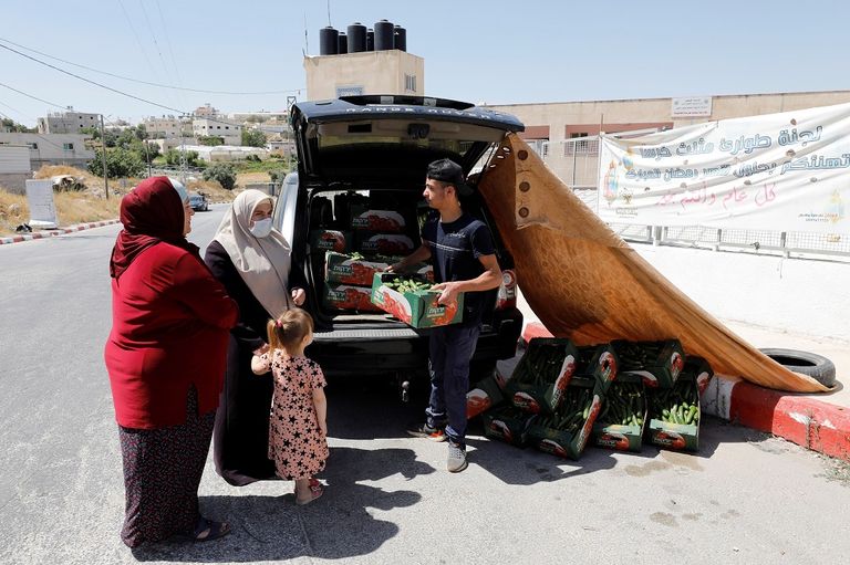 المزارع الفلسطيني محمود أبو مقدام يحمل أحد صناديق الخيار
