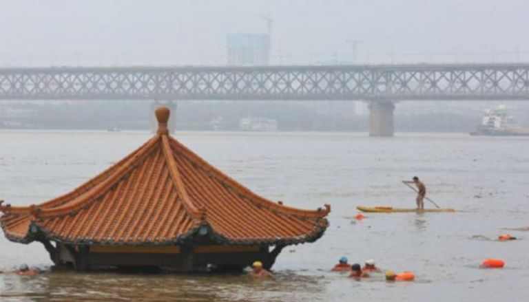 أشخاص يسبحون في مياه الفيضانات بإقليم هوبي الصيني