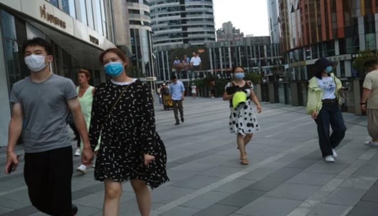 أشخاص يرتدون كمامات للوقاية من عدوى كورونا في الصين