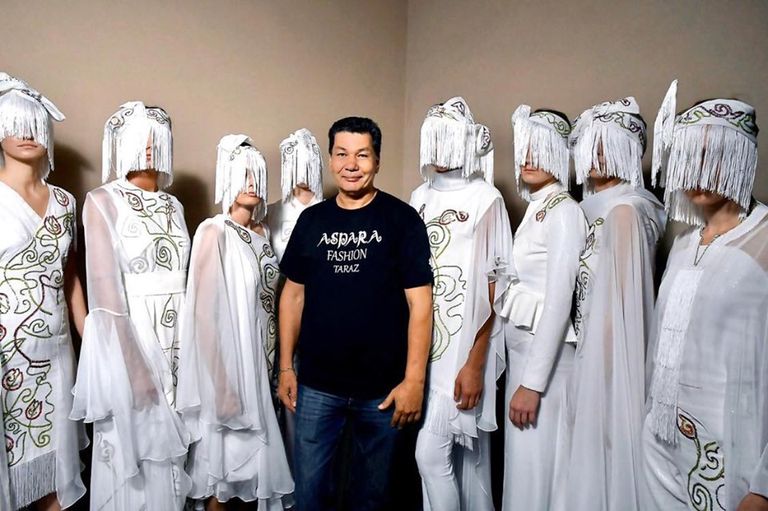 إيدارخان كالييف بجانب مجموعة من تصميماته