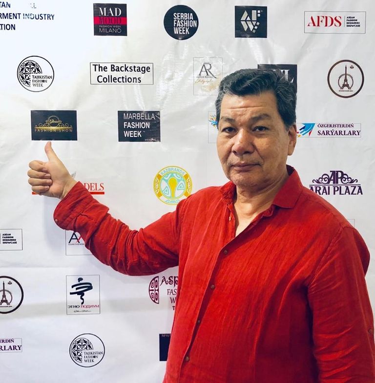 إيدارخان كالييف بجانب مجموعة من تصميماته