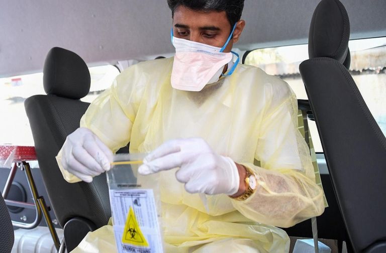 أم وابنتها ترتديان قناعا بينما تعبران طريقا في مدينة كلكتا الهندية