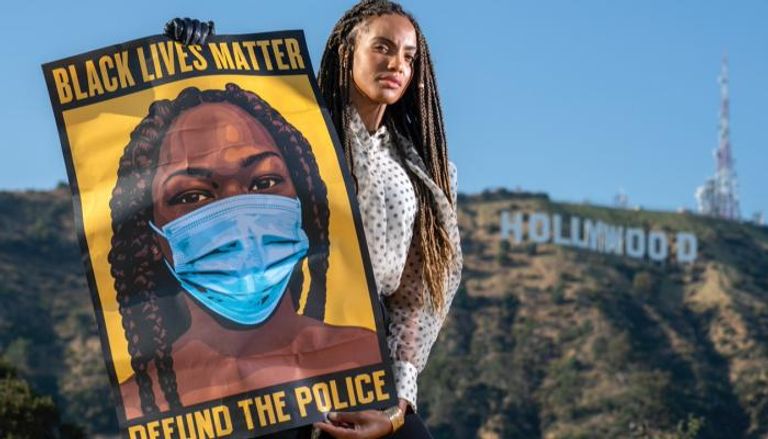 فنانة تحمل لافتة لحركة "حياة السود مهمة"