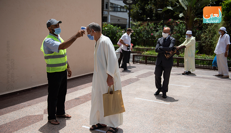 شاب يقيس درجة حرارة المصليين والالتزام بالتباعد الاجتماعي قبل دخول مسجد في المغرب المصلون يعودون لمساجد المغرب