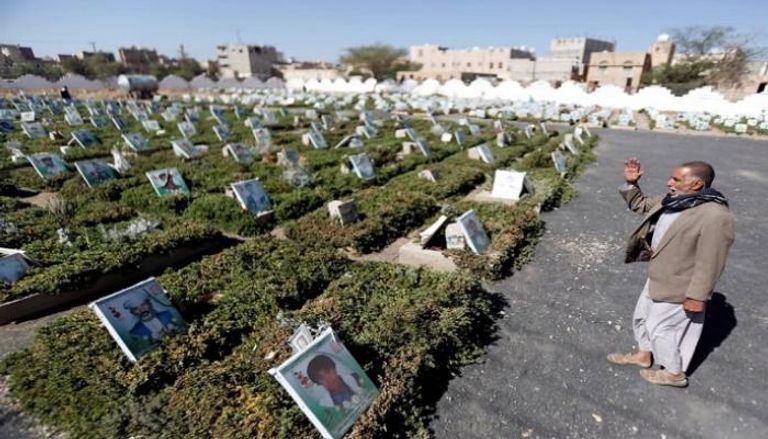 يمني يقف في إحدى المقابر التي تحوي رفات مليشيات الحوثي
